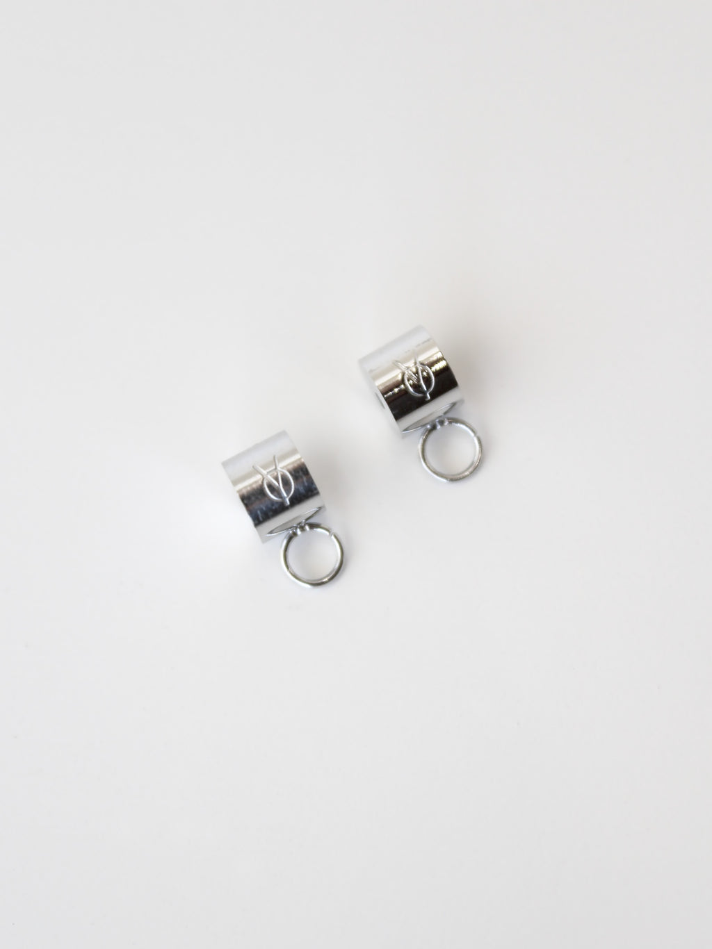 Two silver earring backs with a logo on a white background