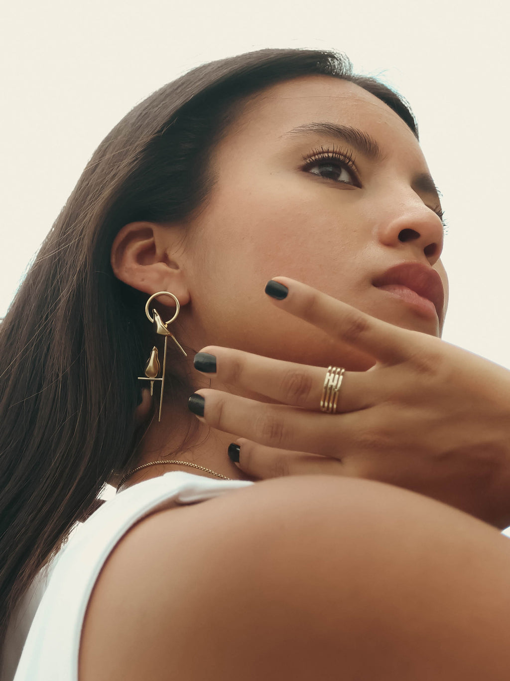 Hero image of gold Perched Bird Earrings and Tile Ring on model. By STUDIYO Jewelry